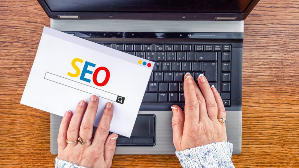 Clavier avec une main tapant sur une touche SEO, symbolisant l'importance du SEO. Tendances SEO 2024.