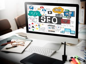 Table de travail avec un écran affichant des éléments graphiques sur l'optimisation SEO réussie.