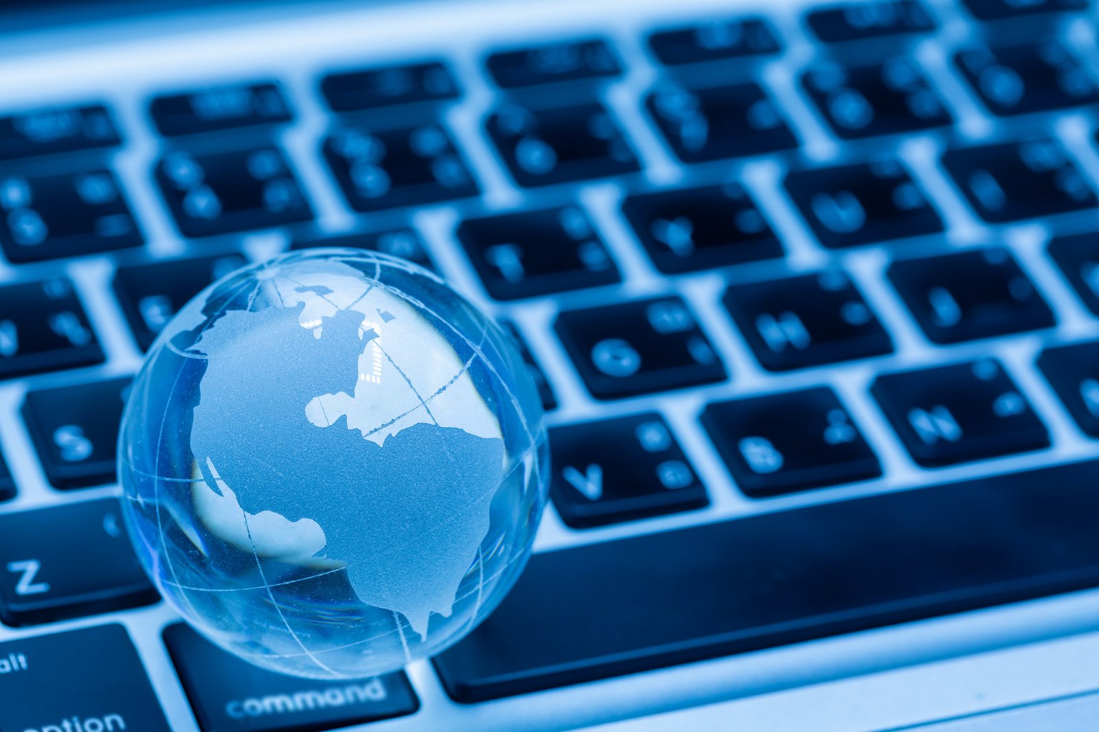 Globe en verre sur un clavier symbolisant l'impact mondial d'une migration SEO réussie.