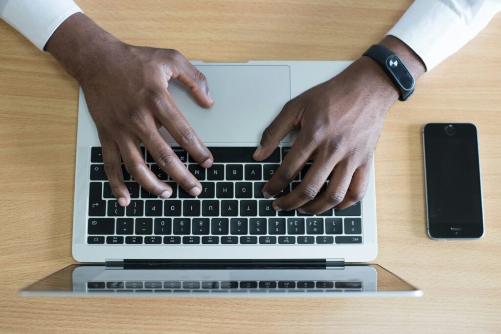 Mains tapant sur un clavier, représentant la rédaction d’une campagne d’emailing efficace.