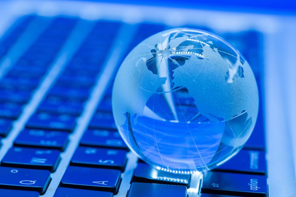 Globe de verre sur un clavier représentant la portée mondiale de l’accessibilité web sur Internet.