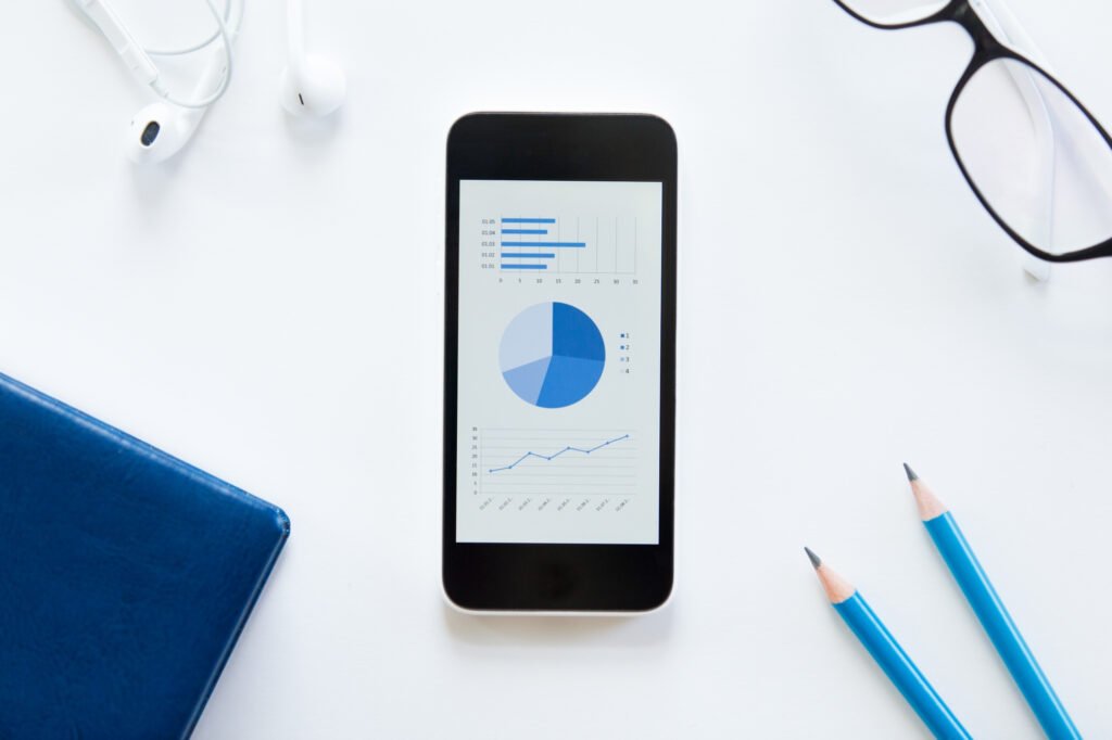 Écran de smartphone affichant des graphiques SEO sur fond blanc, outil d’analyse du SEO local mobile.