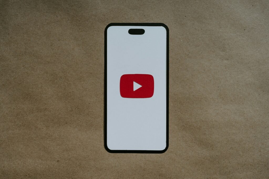 Icône YouTube sur écran mobile représentant l’adaptation du contenu vidéo au SEO mobile.