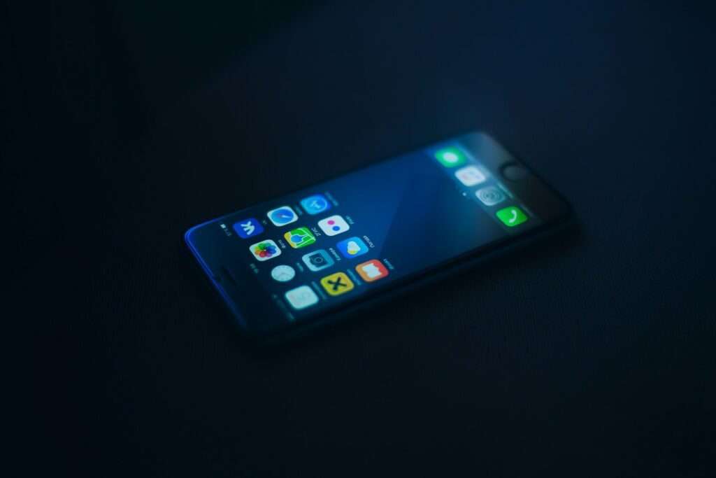 Applications mobiles affichées sur écran dans un environnement sombre, référence au SEO mobile nocturne.